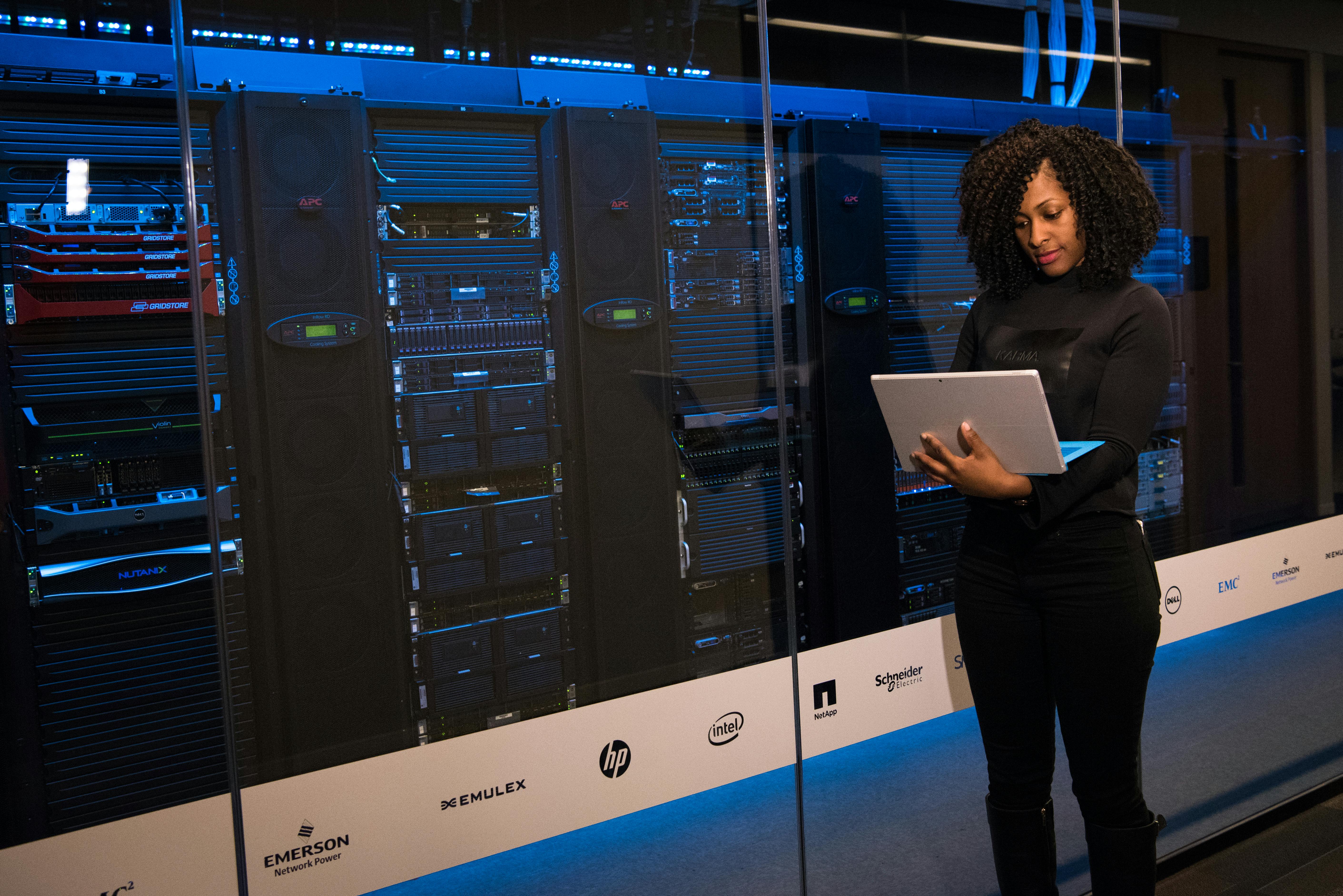 Woman on laptop in front of data center